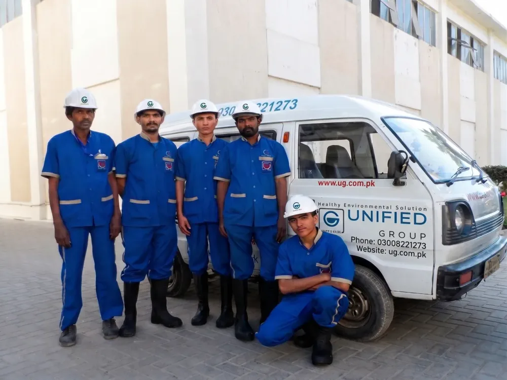 Unified Group technicians with the branded service van at a Karachi job site